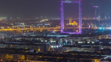 Zabeel Mescidi ile Dubai Çerçeve gece zaman atlamalı aydınlatılmış. Yukarıdan havadan görünüm. Çerçeve Zabeel Park mimari bir dönüm noktası.