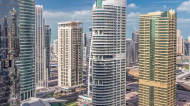 Dubai'de Jumeirah göl kuleleri ilçe timelapse konut daire ve ofisler. Mavi gökyüzünde modern gökdelenler ve bulutlar ile yukarıdan havadan görünüm