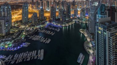 Dubai Marina, gökdelenleri ve Jumeirah göl kulelerini aydınlatmış ve Birleşik Arap Emirlikleri 'nde gece gündüz geçiş zamanlarına kadar panoramik manzara sağlamıştır. Yolda trafik ve yüzen tekneler.