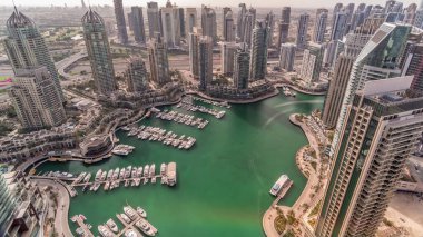 Dubai Marina gökdelenleri ve Jumeirah göl kuleleri, Birleşik Arap Emirlikleri 'nde gölgelerin hızla hareket ettiği tüm gün boyunca en tepedeki hava zaman diliminden görülebiliyor. Yolda trafik vardı.
