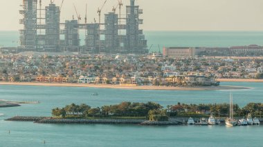 Palm Jumeirah aerial timelapse during sunset. View from Internet city with construction site and villas. Dubai, United Arab Emirates clipart