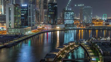 Parlak gökdelenleri ve lüks küçük evleri olan gece şehri Business Bay, Dubai, Birleşik Arap Emirlikleri 'ndeki kanalların yakınında.