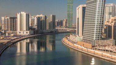 Aerial view of constructing skyscrapers timelapse with blue sky near beautiful canal and waterfront in Business Bay, Dubai, United Arab Emirates clipart