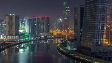 Gece gündüz kanal yakınlarındaki devasa gökdelenlerin hava görüntüsü Business Bay, Dubai, Birleşik Arap Emirlikleri 'ndeki geçiş zamanı..
