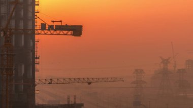 Yeni modern gökdelenler inşa etmek. Şafak ve elektrik hatları inşa edildiği sırada inşa edilecek. İşletme Körfezi, Dubai, Birleşik Arap Emirlikleri 'nde yoğun trafiği olan yolların havadan görünüşü