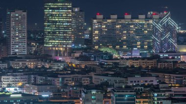 Dubai, Dubai, Birleşik Arap Emirlikleri yakınlarındaki ofis gökdelenleri ve küçük çekici evlerin aydınlatılmış pencereleriyle gece Dubai manzarası