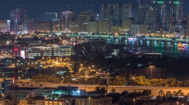 Şehrin güzel manzarası gökdelenlerden gelen ışıklar ve nehir üzerindeki aydınlık yatlarla Deira ve Dubai Nehrinde gece vakti havadan çekilmiş zaman çizelgesi, Birleşik Arap Emirlikleri