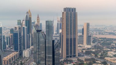 Modern gökdelenler ile Dubai Uluslararası Finans Merkezi ilçe gece geçiş timelapse gün. Gün batımından sonra sokaklarda trafik ile Downtown havadan görünümü