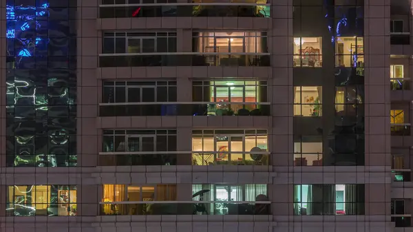 外のアパートの建物のタイムラプスの夜景 高層ビルの中を人が動く窓が点滅する高層ビル — ストック写真