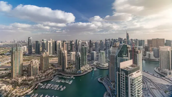 Dubai Marina gökdelenleri ve Jumeirah göl kuleleri Birleşik Arap Emirlikleri 'nde yatları ve tekneleri olan havadan panoramik görüntüler. Bulutlu bir yolda trafik