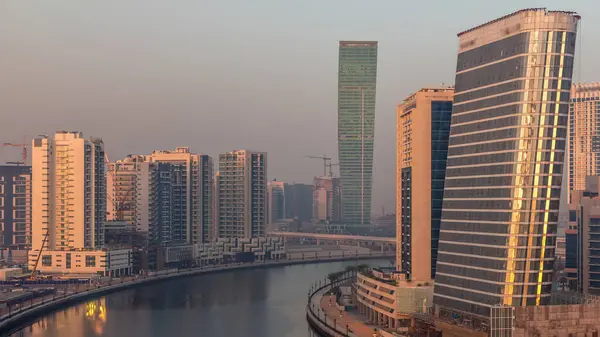 ビジネスベイで日の出のタイムラプス中の早朝に現代の高層ビルの間の魅力的な運河の空中ビューは 影が急速に移動し ドバイ アラブ首長国連邦 — ストック写真