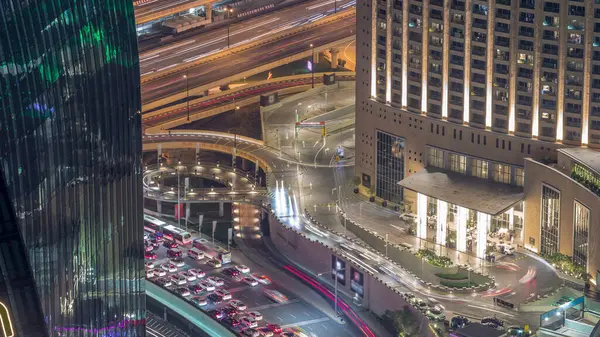 Dubai downtown street with busy traffic and skyscrapers around night timelapse. Modern road and urban buildings with mall aerial view. Sheikh Mohammed bin Rashid Blvd
