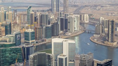 Dubai'deki iş bölümü kulelerinin panoramik havadan görünümü akşam saatinde. Yapım aşamasındaki bazı gökdelenler, kanal ve yeni kulelerin çatı görünümü.