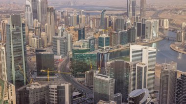 Dubai'deki iş bölümü kulelerinin panoramik havadan görünümü akşam saatinde. Yapım aşamasındaki bazı gökdelenler, kanal ve yeni kulelerin çatı görünümü.