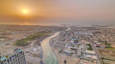 Gün batımında Dubai sahil şeridinin panoraması ve havadan görünümü, Birleşik Arap Emirlikleri. Dubai su kanalı, şeyh zayed yol, yukarıdan evler ve villalar