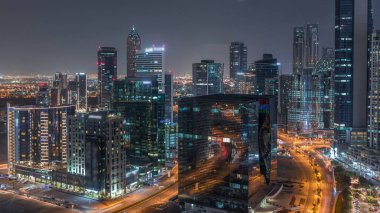 İş hanı gece kuleleri aydınlatıyordu. Kanal yakınlarındaki bazı gökdelenlerin çatı manzarası ve inşaat halindeki yeni kuleler. Kavşağı olan yollarda trafik ve pencerelerde ışıklar