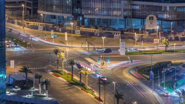 Aerial top view city traffic on a crossroad in Dubai Business bay night timelapse. Road junction from above, automobile traffic and jam of many cars, transportation motion