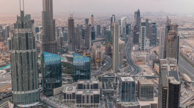 Dubai Downtown silueti fütüristik şehir manzarası ile birçok gökdelenler ve Burj Khalifa hava timelapse. Modern kuleler ve çatıdan inşaat ile gün doğumu sırasında Sabah panorama