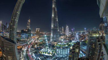 Dubai şehir merkezindeki panoramik gökyüzü manzarası, alışveriş merkezi, çeşmeler ve Burj Khalifa 'nın hava gece zaman çizelgesi. Modern ışıklandırılmış gökdelenler ve inşaat alanı