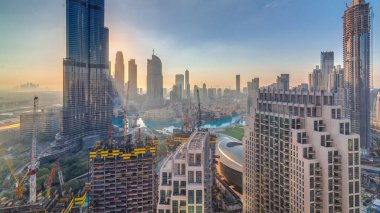 Gün doğumunda Dubai 'nin panoramik ufuk çizgisi manzarası. Alışveriş merkezi, çeşmeler ve Burj Khalifa' nın sabah hava saatleri. Modern gökdelenler ve güneş ışınlı bulutlu gökyüzü