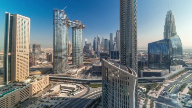 Yeni kulelerin ve yoğun yolları olan yüksek binaların havadan görünüşü tüm gün boyunca uzun gölgelerle Dubai şehir merkezinden hızla ilerlerken otoyol, Dubai, Birleşik Arap Emirlikleri 'nde trafik vardı.