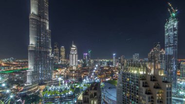 Şehir merkezindeki Dubai 'nin panoramik ufuk çizgisi manzarası. Alışveriş merkezi, çeşmeler ve Burj Halife' nin zaman çizelgesi tüm gece boyunca yanıp sönüyor. Modern ışıklandırılmış gökdelenler ve inşaat alanı