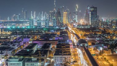 Güzel şehir merkezi ışıkları ve Şeyh Zayed yol trafik gece timelapse ile Dubai silueti. Zabeel semtinden ışıklı kuleler ve gökdelenler havadan görünüm. Dubai, Birleşik Arap Emirlikleri