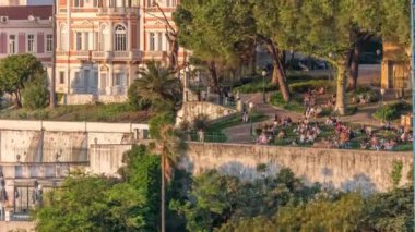 Geleneksel bir bahçe ve Lizbon şehir merkezine akşam boyunca alışılmadık manzaralı Jardim do Torel zaman çizelgesi. İnsanlar terasta gün batımını seyrediyor. Portekiz