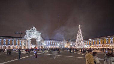 Panorama, Ticaret Meydanı 'nın ışıklandırılmış kemerini ve Lizbon' da Noel zamanında süslenmiş halini gösteriyor. Noel ağacı ve insanların toplandığı bir meydan. Tatil zamanları. Portekiz