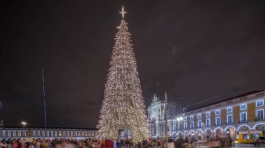 Panorama, Lizbon 'da Noel zamanı Ticaret Meydanı' nın aydınlatıldığını ve süslendiğini gösteriyor. Noel ağacı ve turistlerin cirit attığı bir meydan. Tatil zamanları. Portekiz