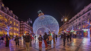 Panorama showing Christmas decorations with big ball on Luis De Camoes square (Praca Luis de Camoes) night timelapse. One of the biggest squares in Lisbon city in Portugal illuminated in the evening clipart