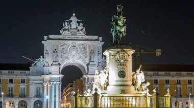 Triumphal arch at Rua Augusta and bronze statue of King Jose I at Commerce square illuminated at night timelapse in Lisbon, Portugal.