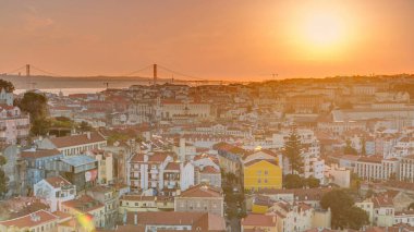 Lizbon gün batımında şehir merkezinin panoramik manzarasında sonbahar akşamında kırmızı çatılar, Portekiz. Sophia de Mello Breyner Andresen 'in bakış açısı. Turuncu gökyüzünde güneş