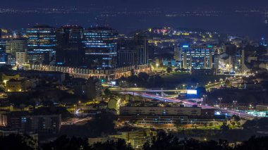 Lizbon ve Almada üzerinde panoramik şafak manzarası Monsanto 'da gece gündüz geçiş zamanı. Trafikli hava manzarası ve alışveriş merkezi olan modern binalar.