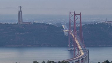 Lisbon and Almada during sunrise with traffic on April 25 bridge from a viewpoint in Monsanto at morning timelapse. Aerial top view with Cristo Rei monument. Foggy weather clipart