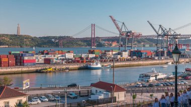 Lizbon ticari liman zaman çizelgesi üzerinde Skyline, 25 Nisan Köprüsü, yük vinçli konteynırlar, Lizbon, Portekiz şehir treni. Gün batımından önce hava görüntüsü