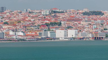 Lizbon Tarihi Merkezi 'nin panoraması Tagus veya Tejo Nehri' nin güney kıyısından izlendi. Kırmızı çatılı binalar ve suda yüzen gemiler.