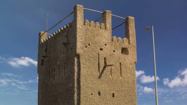 Watch tower of Ajman timelapse with blue cloudy sky. United Arab Emirates. Sunny day clipart