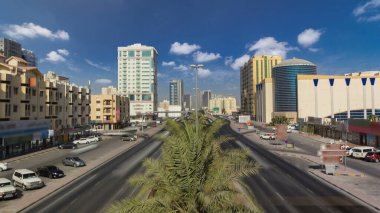Ajman 'da yol trafiği, gündüz vakti köprüden görüntüler. Birleşik Arap Emirlikleri 'nin arka planında kuleleri olan kentsel hava manzarası.