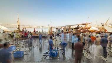 Seafood at the fish market in emirate of Ajman timelapse. Fishers sell many types of fishes near boat on shore clipart