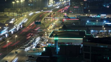 Gece vakti çatıdan Ajman hava manzaralı bir köprüde trafik vardı. Birleşik Arap Emirlikleri 'nde üst geçitle kesişen birçok araba var..
