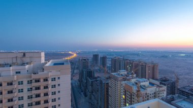 Ajman 'ın çatıdan şehir manzarası. Gün doğumundan gündüze geçiş zamanından önce. Yeni inşaat halindeki bölgeye havadan panoramik görüntü. Birleşik Arap Emirlikleri.