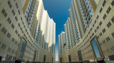 Ajman zaman ayarlı hiperhızlandırılmış modern yeni kuleler. Ajman 'ın yerleşim yeri ve ofis gökdelenleri olan şehir manzarası. İç avluda. Birleşik Arap Emirlikleri.