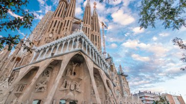 Sagrada Familia Timelapse Hyperlapse, Barcelona, İspanya 'da. Büyüleyici Sonbahar Sahnesi, Yeşil Ağaçlarla süslenmiş Mavi Bulutlu Gökyüzüne karşı