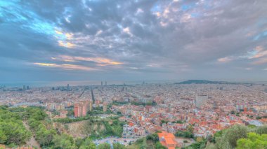 Barcelona Panoraması gündoğumu timelapse, İspanya, sırasında ışık ışınları ile bulutlu bir sabahı Carmel sığınaklar görüş. Hill Hava üstten görünüm. Renkli gökyüzü