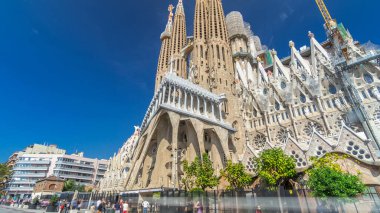 Sagrada Familia: İspanya 'nın Barcelona kentindeki Iconic Roma Katolik Kilisesi' nden Timelapse Hyperlapse. Sonbaharın Zarif Yeşilliği ve Mavi Bulutlu Gökyüzünün Altında Açılan Mimari Mucizeye Şahit Ol.