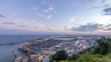 Barcelona Limanı 'ndaki Liman ve Yükleme İskeleleri' nin Gece Dönüşüm Süreci. Montjuic Hill 'den Aerial Top View, Günbatımından sonra şehrin ışıklarıyla sahneyi aydınlatıyor.