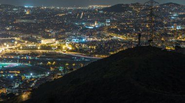 Evler ve ufuk gece timelapse denizde çatılar ile Barcelona ve Badalona manzarası. Tepenin üstüne Iberic Puig İspanya köyü açısından havadan görünümü