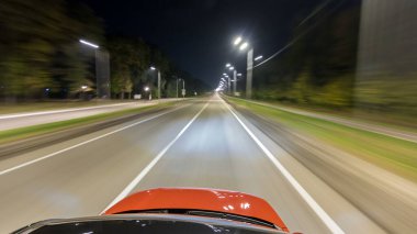 Otobanın en üst kısmından sürtünme gece otobanında süratle ilerliyor. Işıklar arabayı yüksek hızda yansıtıyor. Modern bir şehrin hızlı ritmi. Bulanık hareket