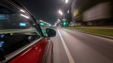 Hızlı sürüş yapan bir şehrin gece caddesinde, yüksek hızda ışık yansıtan bir yolda, hızlı sürüş yapan bir arabadan saçma sapan bir şehir görüntüsü. Modern bir şehrin hızlı ritmi. Bulanık hareket